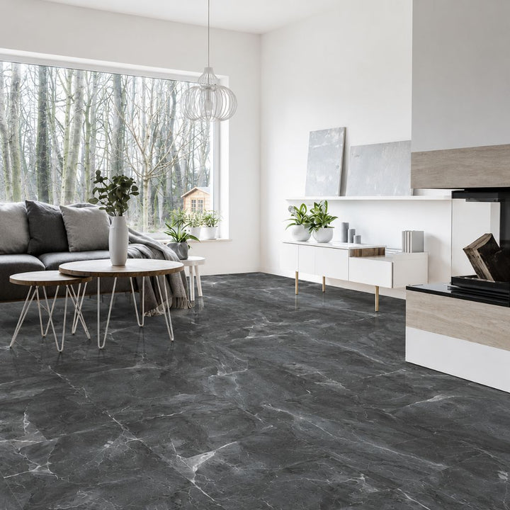 Moderner, heller Wohnraum mit großformatigem dunkelgrauem Marmorboden in Hochglanzoptik. Große Fensterfront mit Blick in einen winterlichen Wald, minimalistische Einrichtung in skandinavischem Stil und elegante graue Marmorstruktur mit feinen weißen Maserungen - REUD-Bodenarena