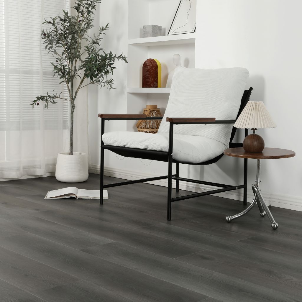 Klick Vinyl Eiche Urban dunkelgrau mit Trittschalldämmung im Wohnraum mit weißem Sessel von Reud Bodenarena