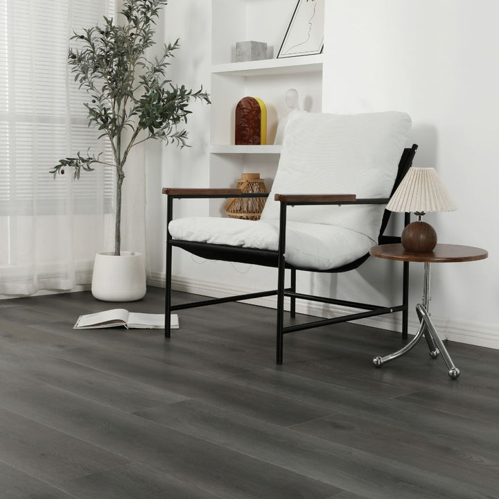 Klick Vinyl Eiche Urban dunkelgrau mit Trittschalldämmung im Wohnraum mit weißem Sessel von Reud Bodenarena