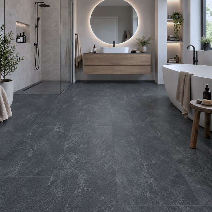 Klick Vinyl Fliesenoptik Saragossa in Dunkelgrau im modernen Badezimmer mit freistehender Wanne – Reud Bodenarena